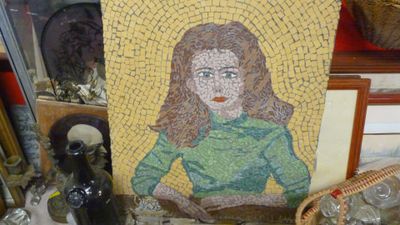 une mosaïque représentant une femme assise sur une table