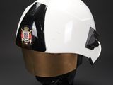 white and gold helmet on a black base on a black background