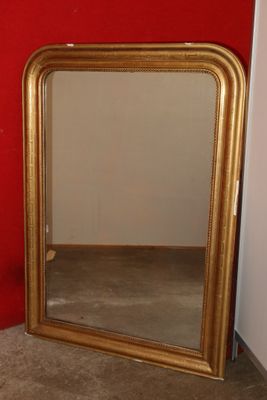 a mirror that is sitting on the floor in front of a red wall