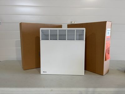 a white air conditioner sitting on a counter next to a brown box