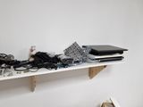 a white shelf with a laptop and other electronics on it