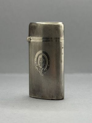 un étui à cigarettes ancien en argent, orné du visage d'un homme