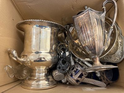 une boîte remplie d'objets en argent qui s'y trouvent