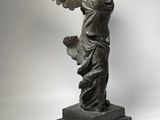 an image of a statue of a woman with wings on a marble base