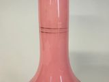 a pink vase with gold designs on it on a table