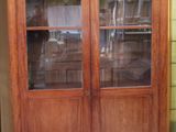 a wooden cabinet with glass doors in a room