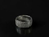a close up of a silver ring on a black surface