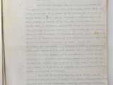 an open book with a handwritten page on it sitting on a table