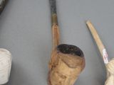 three different types of pipes and a pipe holder on a table