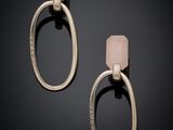 a pair of earrings with a pink stone on a black background