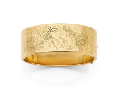 un gros plan d'un bracelet en or orné d'un motif