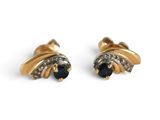 une paire de boucles d'oreilles en saphir et diamants sur fond blanc