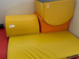 a red and yellow bed with a yellow pillow on it
