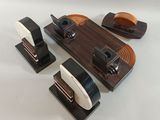 three pieces of wood and metal on display on a white surface