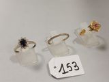 trois bagues et une bague posée sur une table, avec une étiquette indiquant son prix