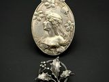 un gros plan d'une médaille et d'une broche posées sur une surface noire
