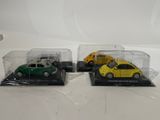 three miniature cars are in a display case on a white surface