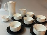 a lot of coffee cups and saucers on the table