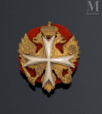 an image of a gold and red broochle with a cross on it