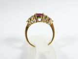 a close up of a gold ring with a ruby stone on it
