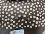 a brown and white vase with polka dots on it