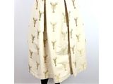 a white skirt with gold deers and trees on it