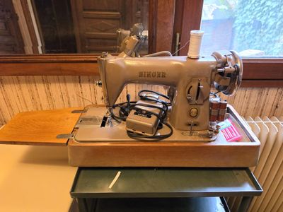 a sewing machine sitting on a table next to a radiator