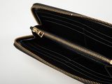 zippered black purse with gold zippers on a white background