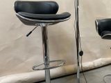 pair of black leather bar stools with chrome base and foot rest
