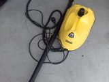 a yellow steam cleaner on the floor next to a pair of shoes