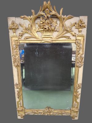 an ornately carved mirror with a gold frame on a green floor