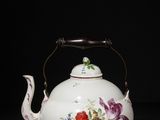 an image of a white teapot with flowers on it on a black surface