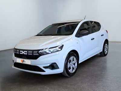 La voiture blanche est garée dans une grande pièce aux murs blancs.