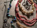 de nombreux colliers et bracelets de toutes sortes posés sur une table