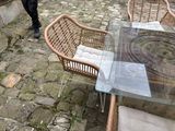 a glass table and chairs on a stone patio