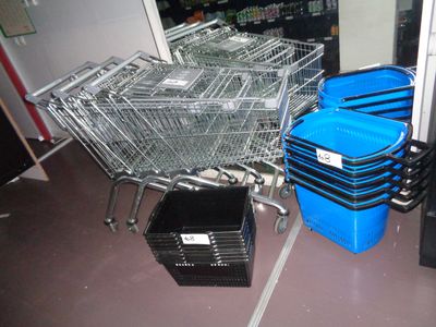 several shopping carts are lined up in a room next to a trash can
