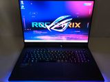 the asus rog strix laptop is lit up with blue and purple lights
