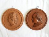 two plaques of women in profile on a white surface