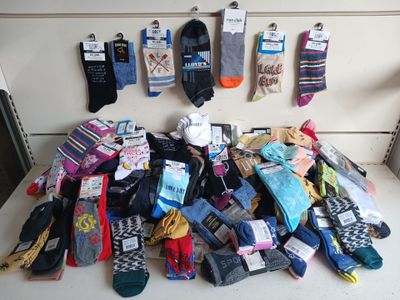 many pairs of socks hanging up on a wall