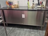 a stainless steel counter in a kitchen with a stainless steel shelf