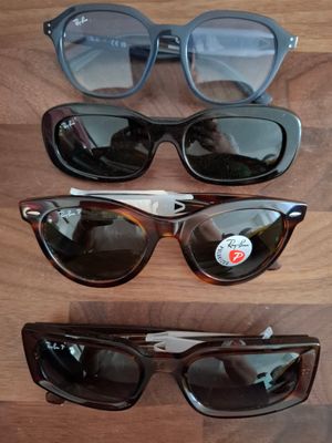 Plusieurs paires de lunettes de soleil sont alignées sur une surface en bois