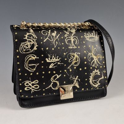 un sac à main noir et doré, orné de clous dorés et d'une chaîne