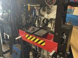 un gros plan sur une machine dans un garage, avec un pneu en arrière-plan