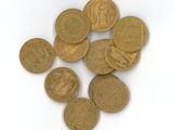 quelques pièces d'or posées sur une surface blanche, sur fond blanc