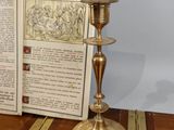 an open book sitting on a table next to a candle holder