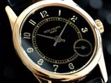 a close up of a gold wrist watch on a black background