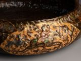 a close up of a brown bowl with designs on it