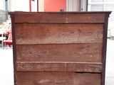 a wooden chest of drawers in a warehouse area