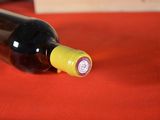 a bottle of wine sitting on a table with a red cloth