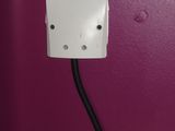 an electrical outlet with a cord connected to it on a purple wall